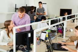 Positive people working with computers and laptops in modern office